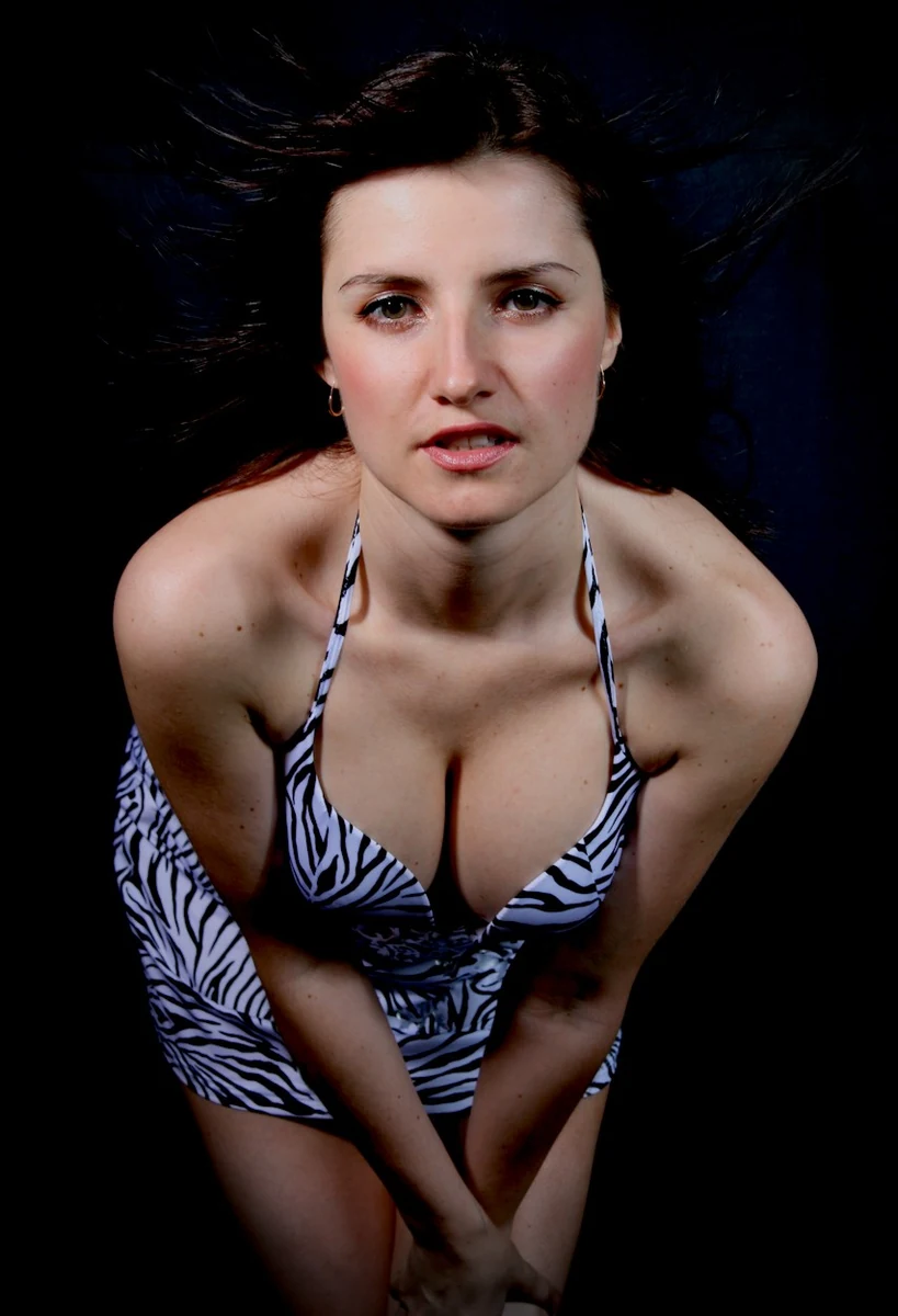 High-angle portrait in a patterned bodysuit against a dark background