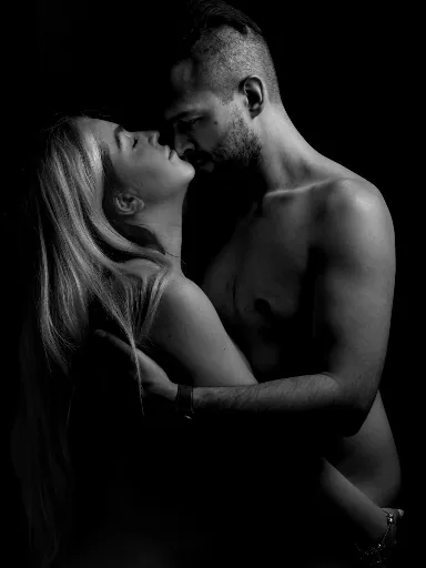 Black and white intimate couple portrait with faces close together in shadow