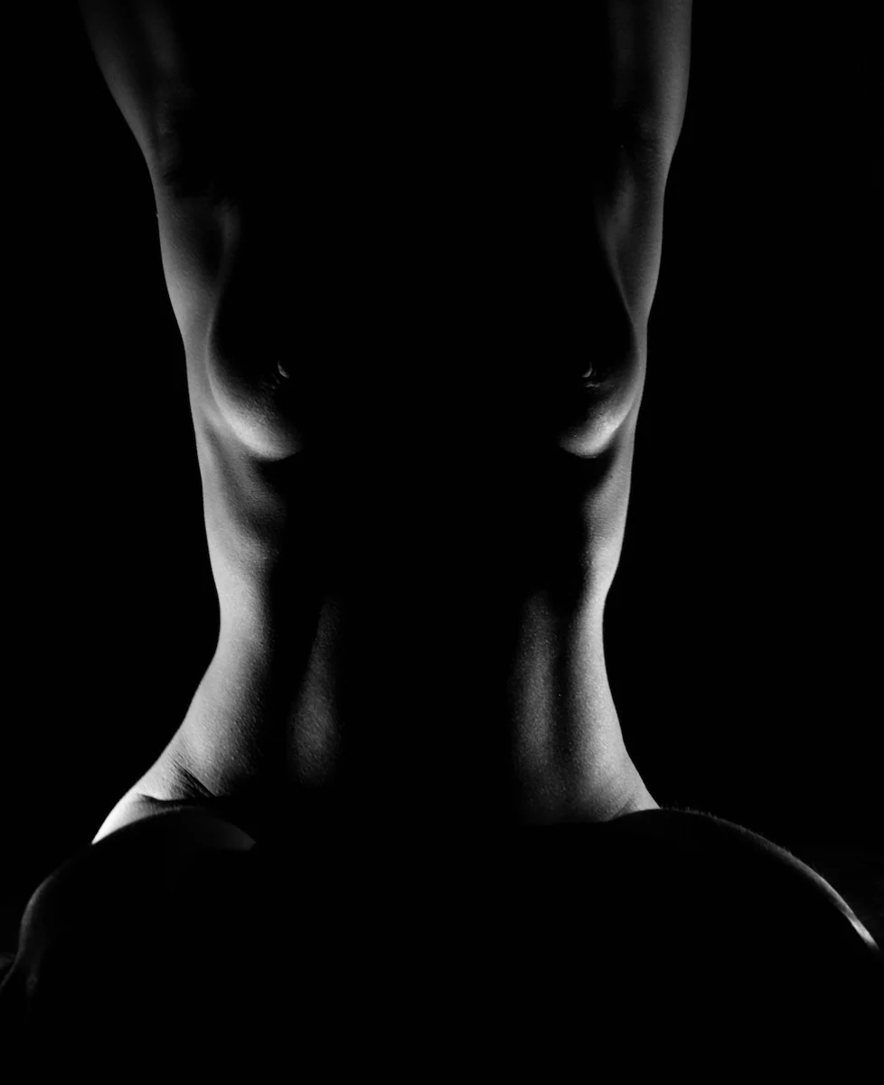 Black and white torso study with rim light on the waist and shoulders