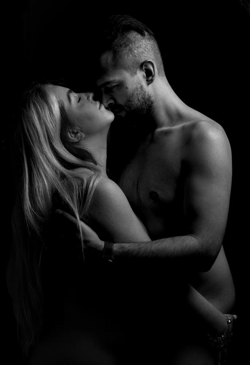 Black and white intimate couple portrait with faces close together in shadow